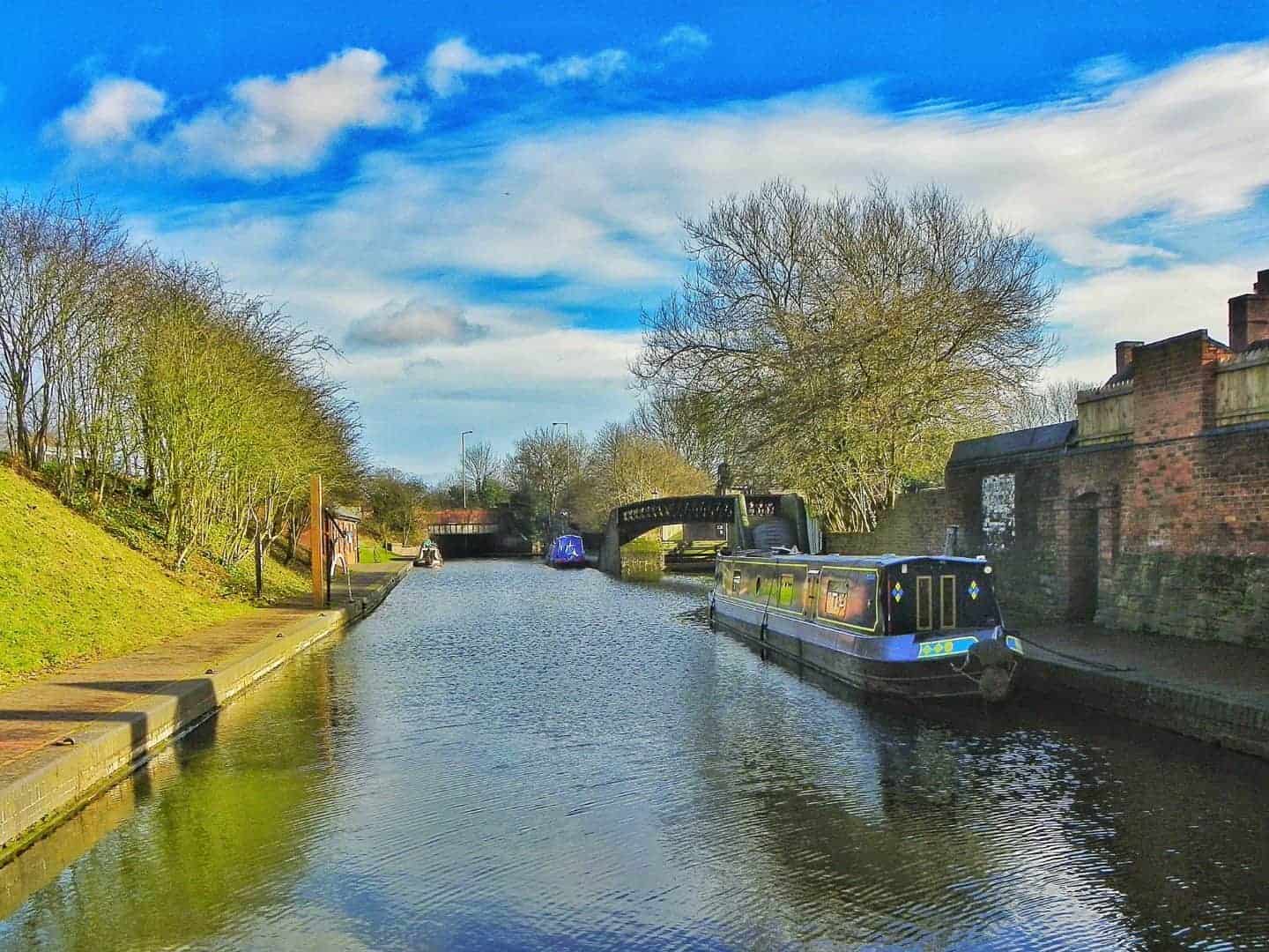 Canal at the Black Country Living Museum with two canal boats on and blue sky with white clouds