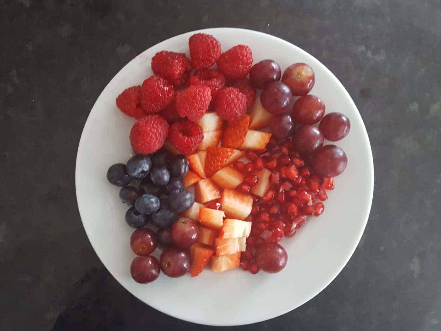 Can you eat too much fruit? Plate full of red berries. 