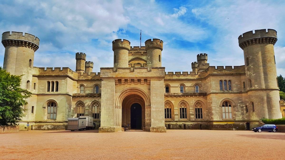 Eastnor Castle in Herefordshire photographed from the front with blue sky above with light white clouds