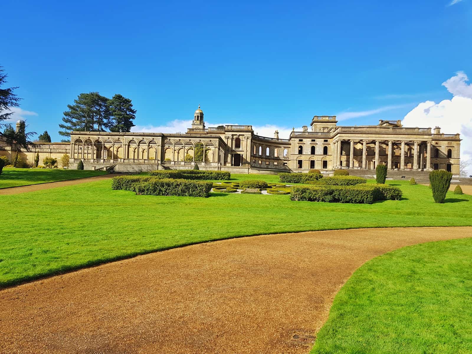 Grass in foreground, Witley Court with blue sky behind