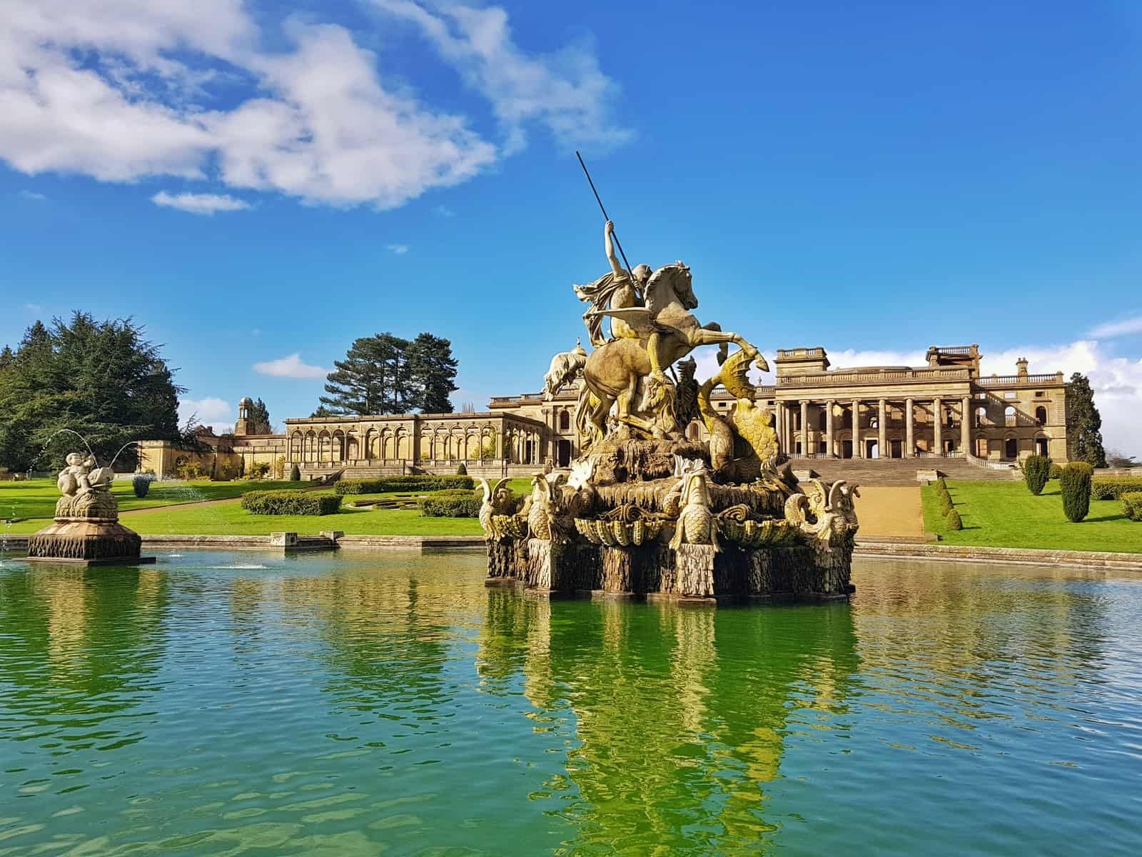 pond and fountain with Witley Court in background and blue sky