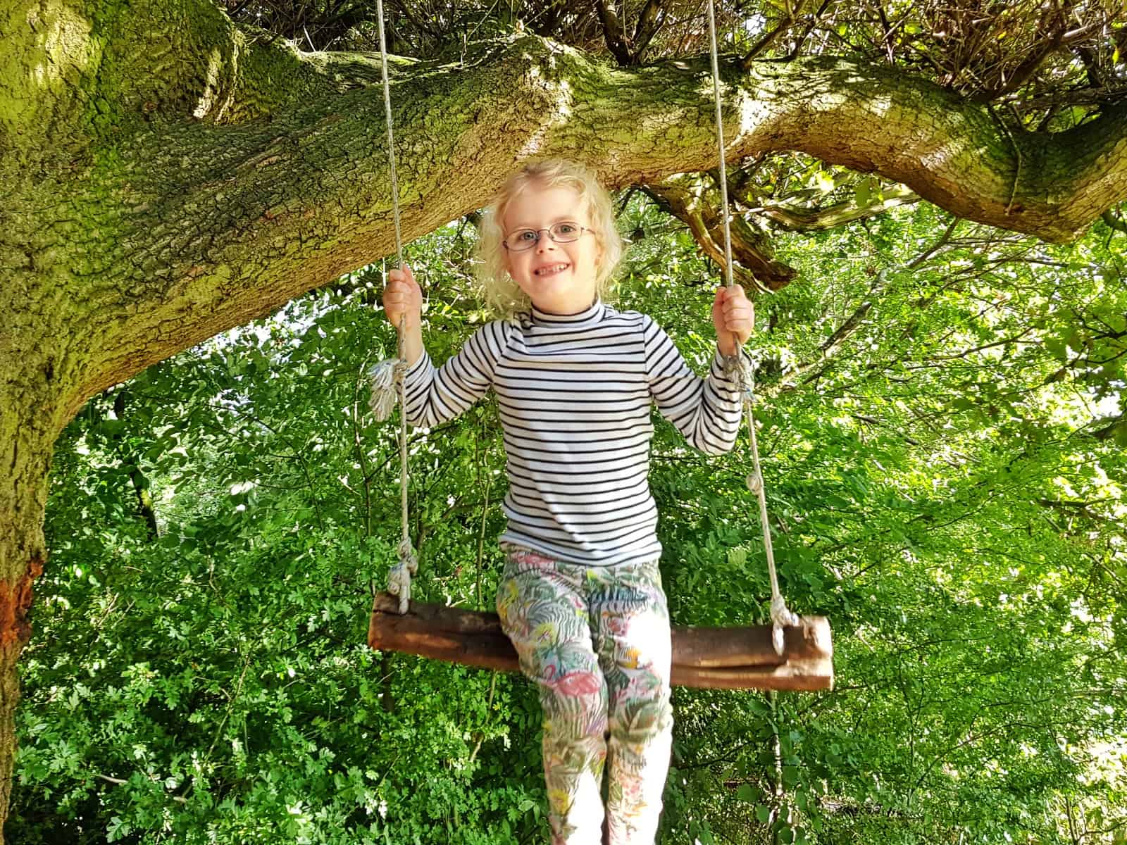 10 tips to prepare your child for tooth extraction girl on a swing before extraction