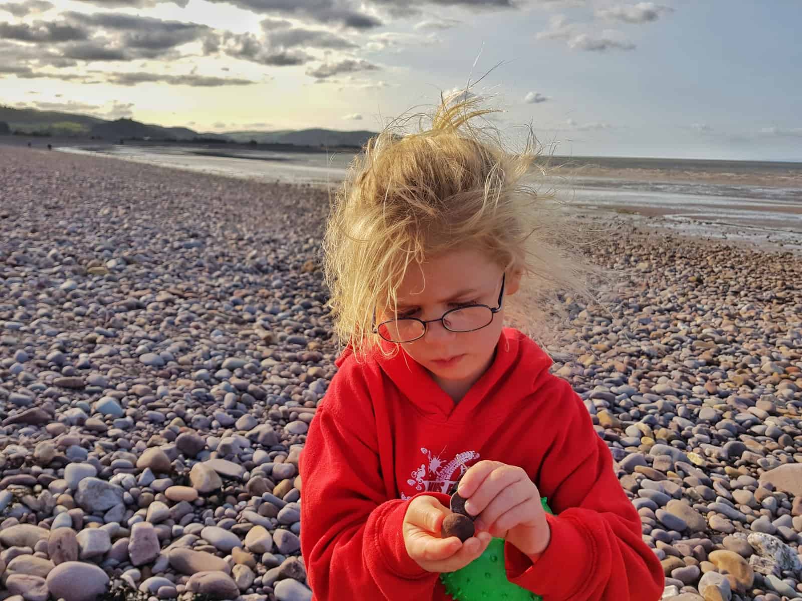 Girl on a pebble beach thinking 