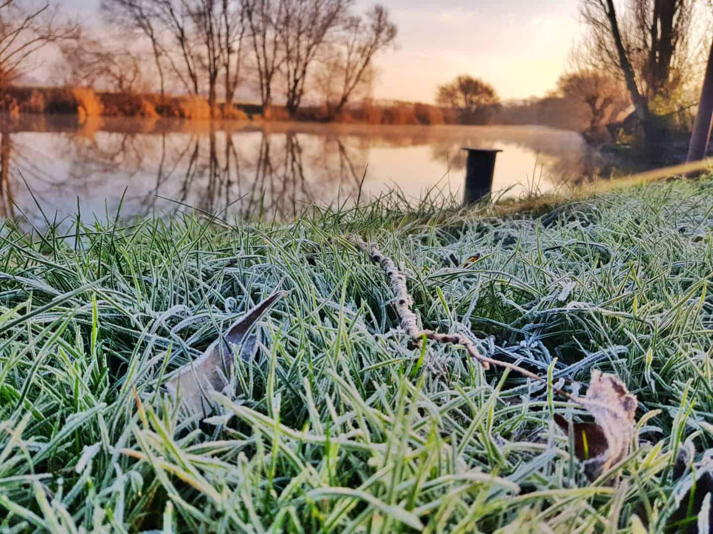 Eckington Bridge in Pershore, Worcestershire viewed from a distance across the river Avon with frosty grass in the foreground