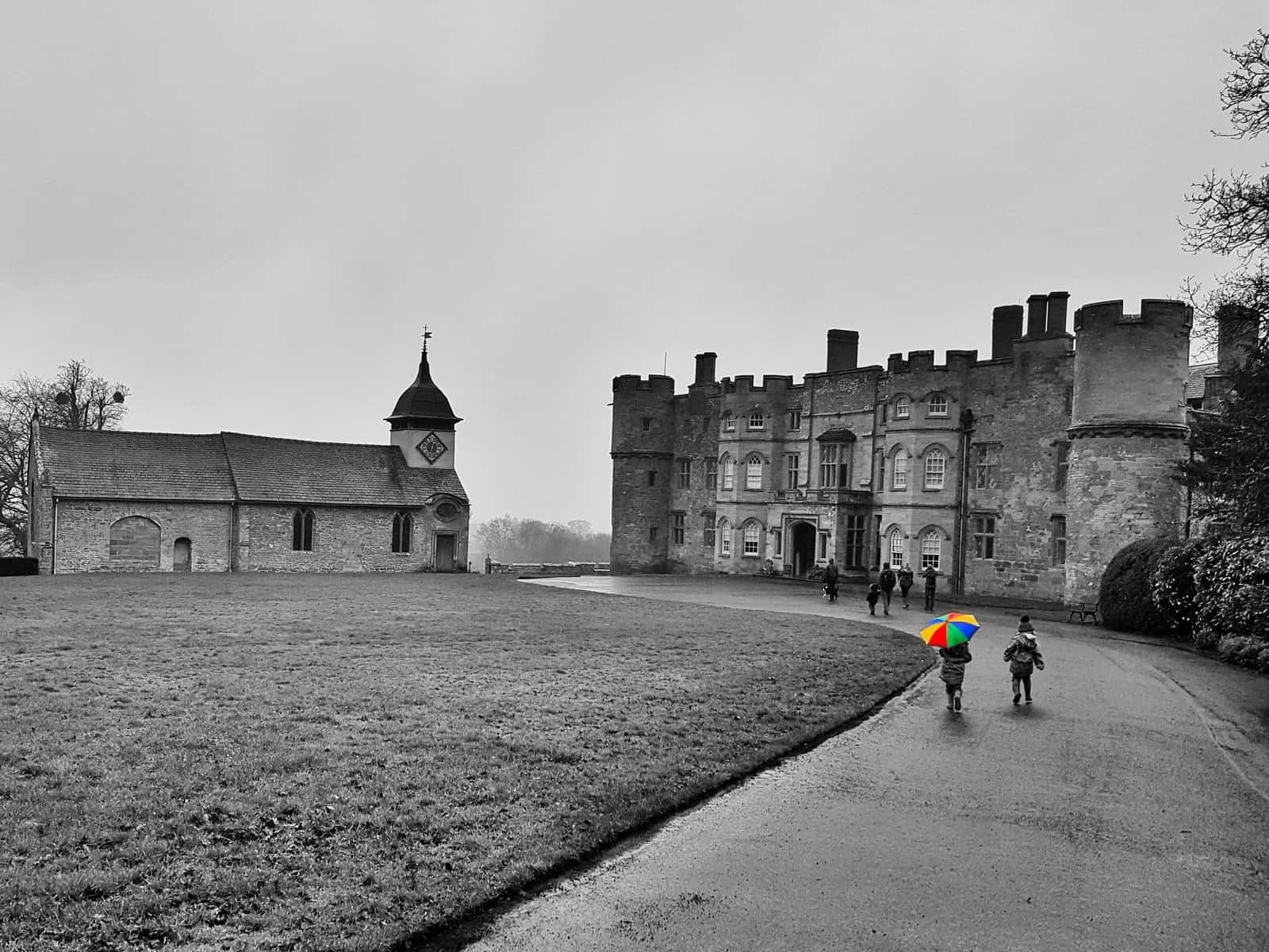 Black and white photo of Croft Castle Herefordshire with rainbow umbrella picked out in colour