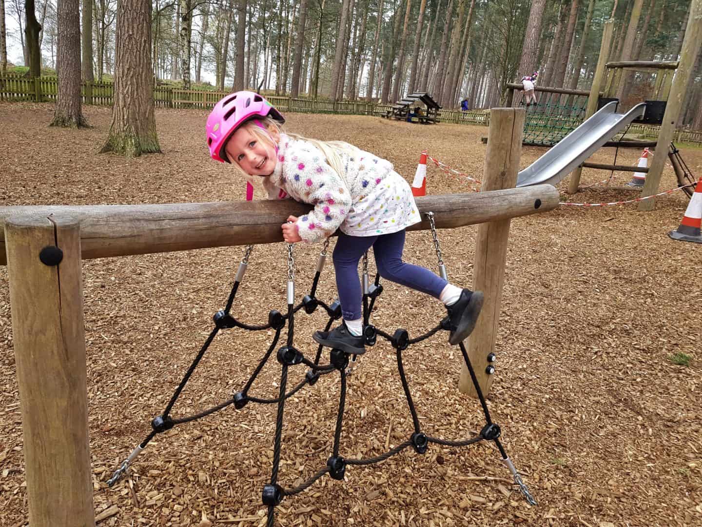 girl climbing small net in playground