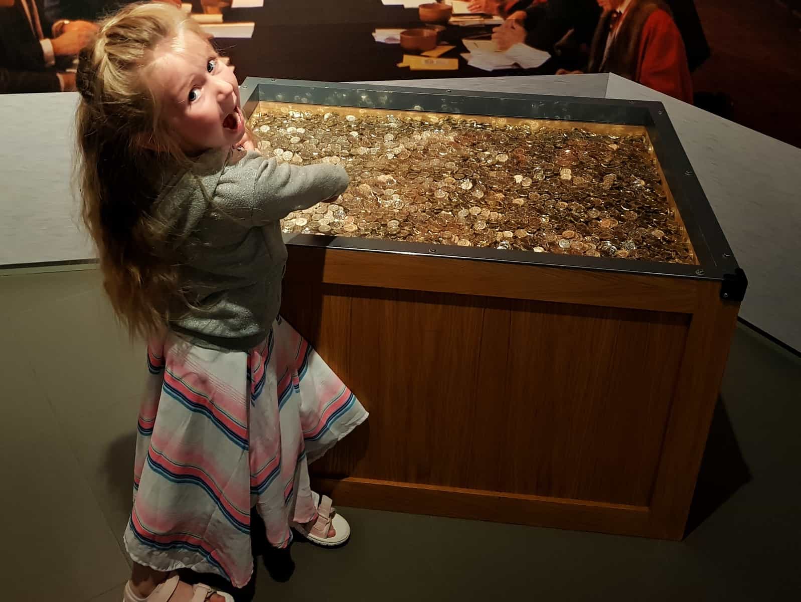 girl by display of pound coins at Royal Mint Experience