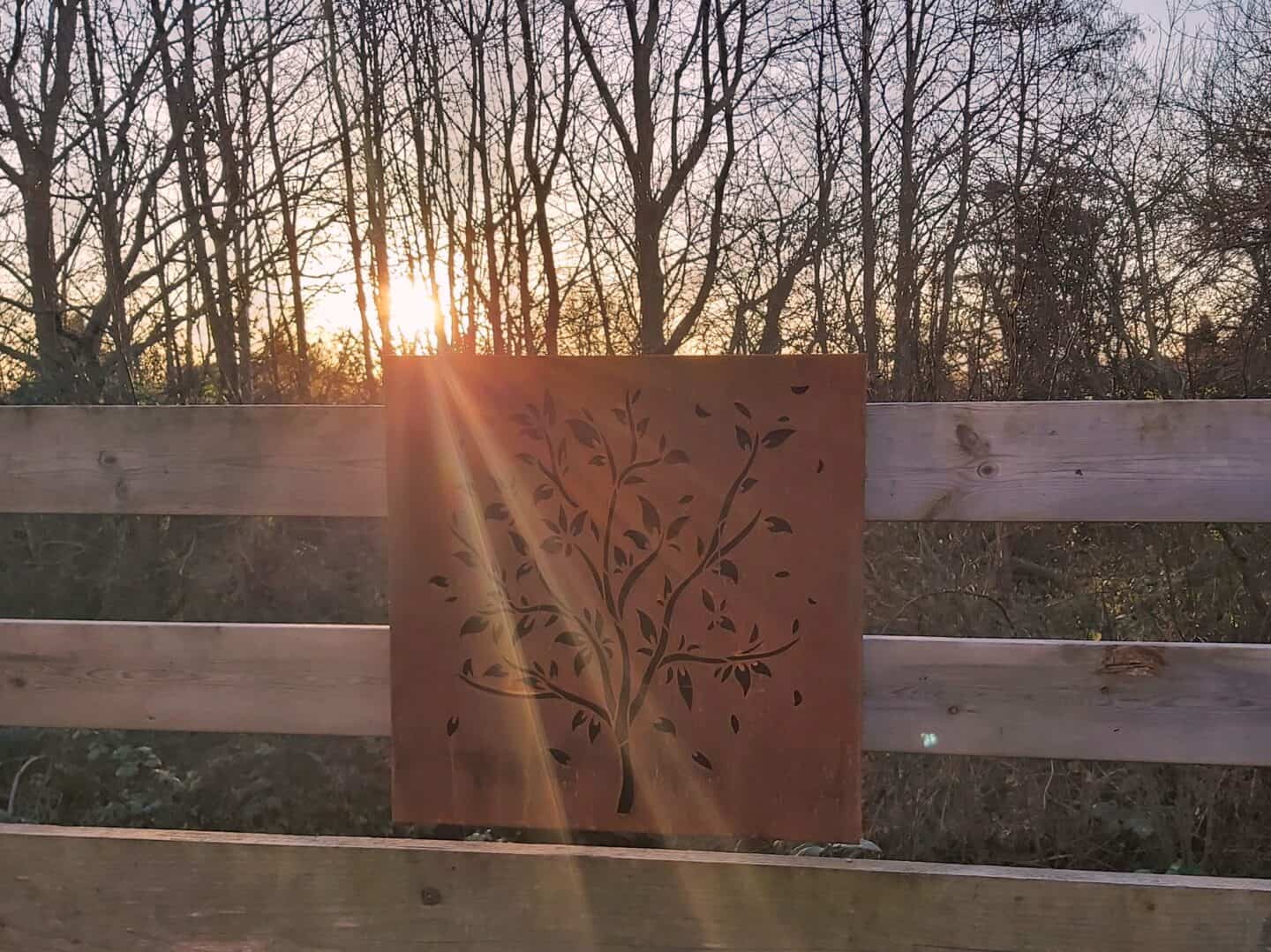 Narla garden artwork with the rising sun shining behind it