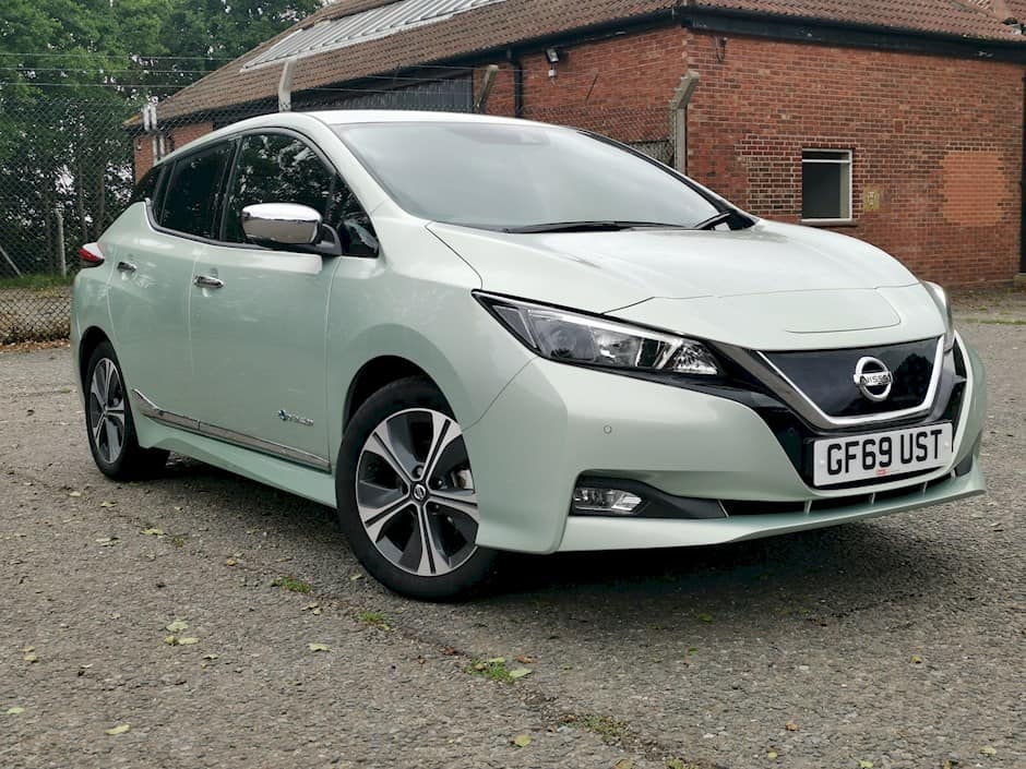 second hand electric car Nissan Leaf in a very pale green colour photographed on a roadside