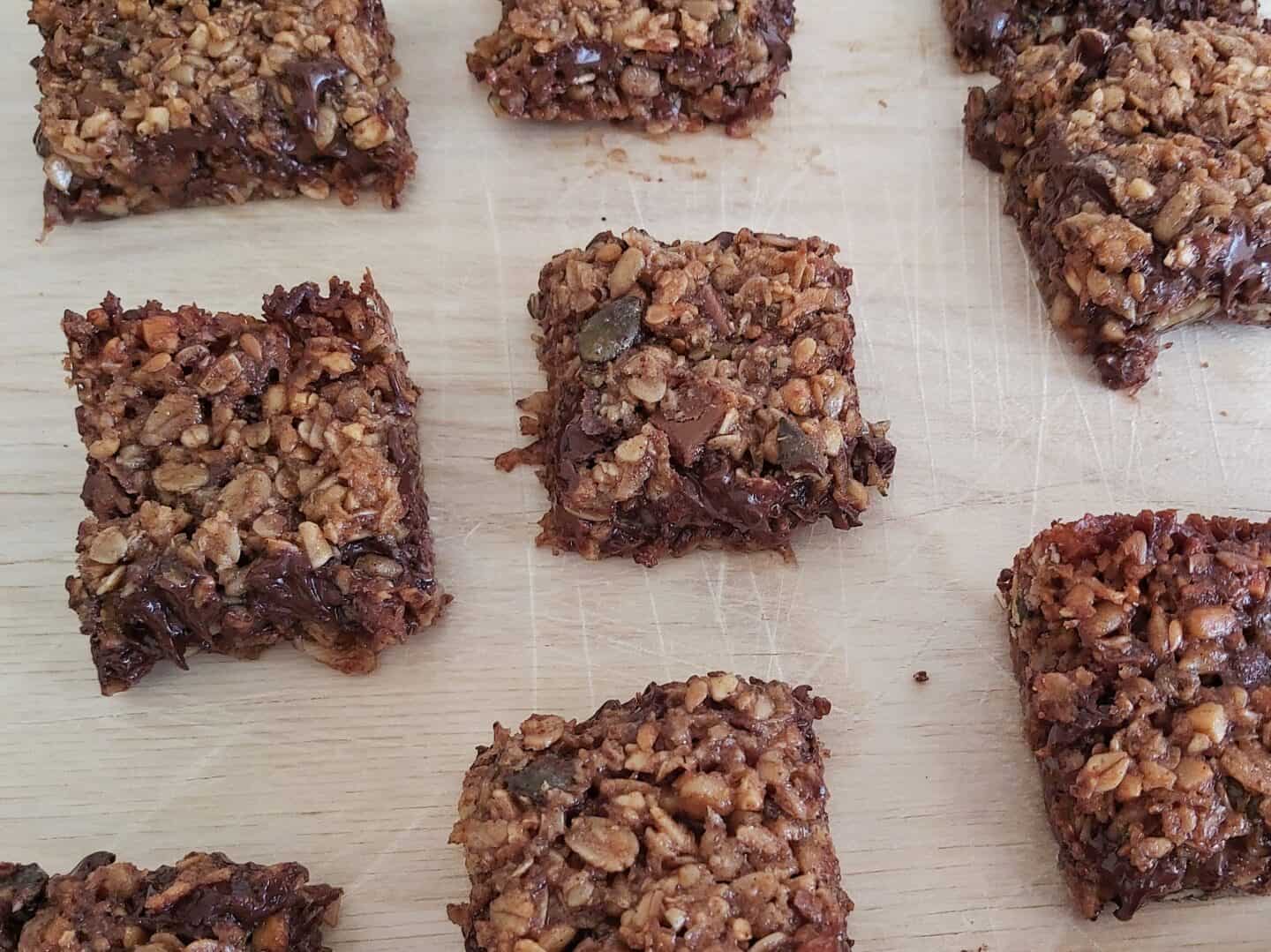 squares of chocolate chip flapjacks on a wooden chopping board