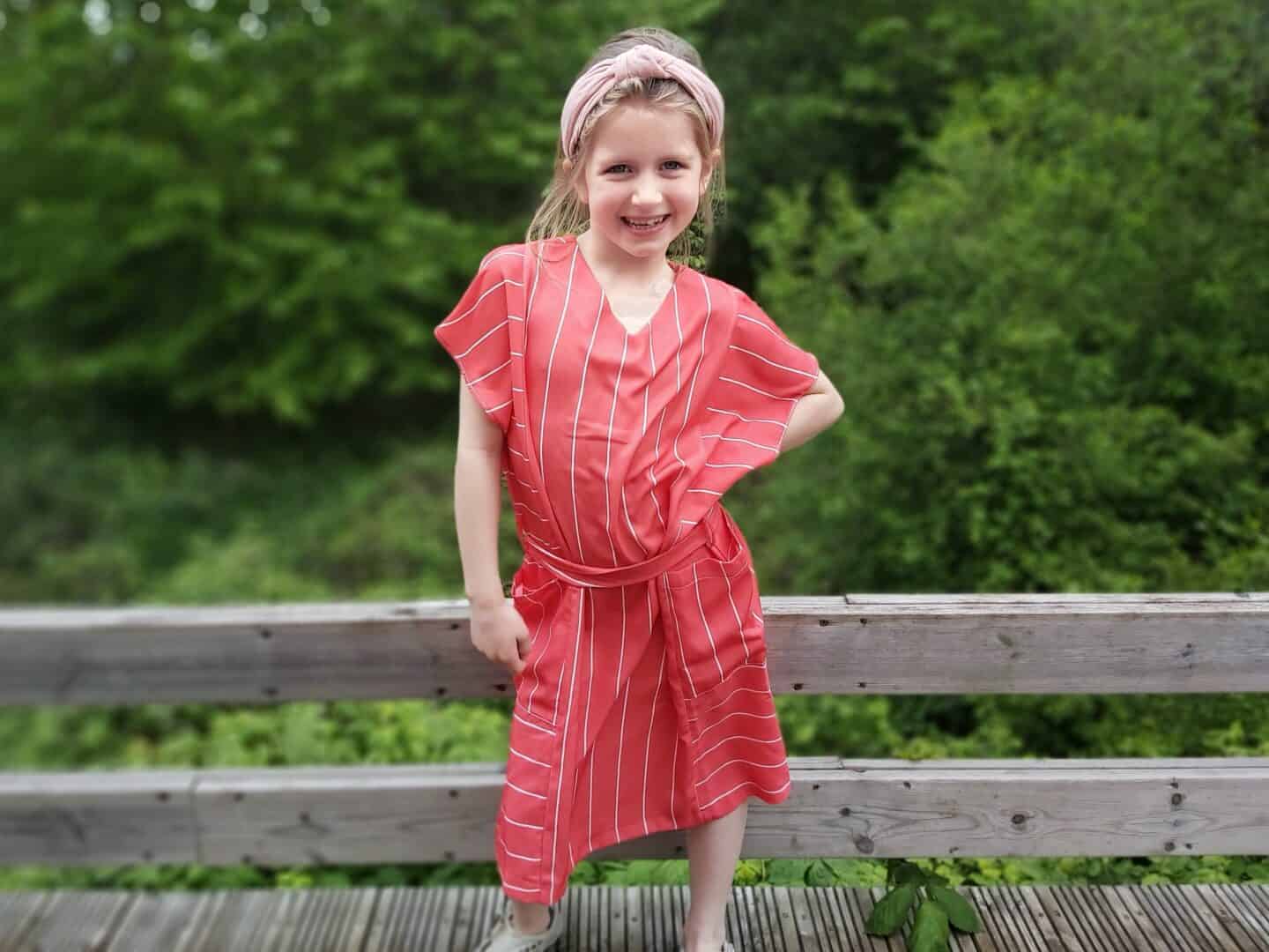 Little girl with hand on hip in casual red striped dress