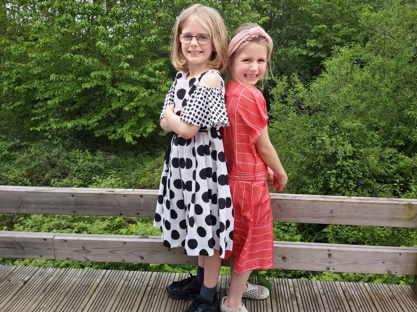 Two girls back to back wearing Chi-Chi London dresses