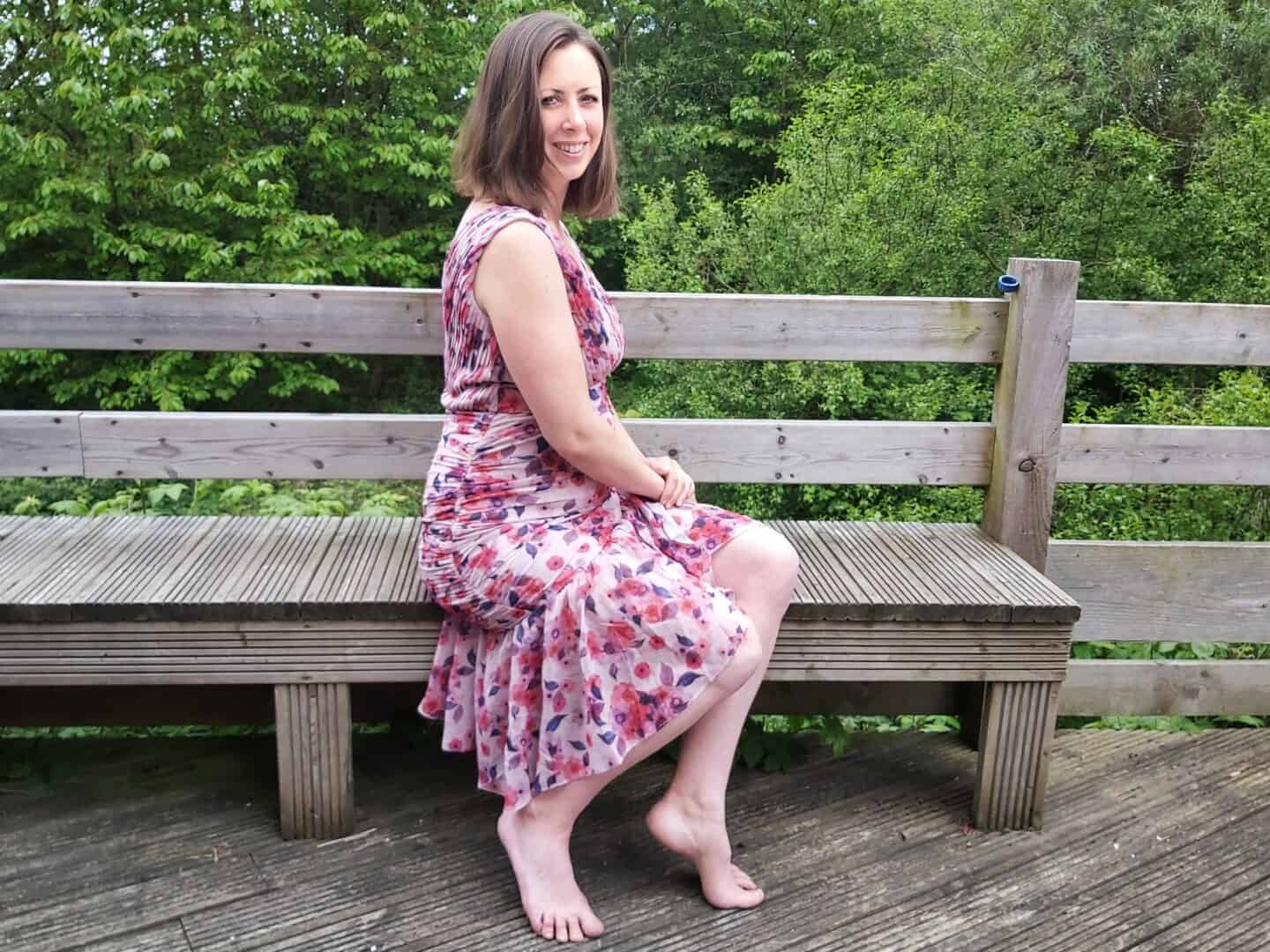 Sitting on a bench in a floral midi dress from Chi Chi London
