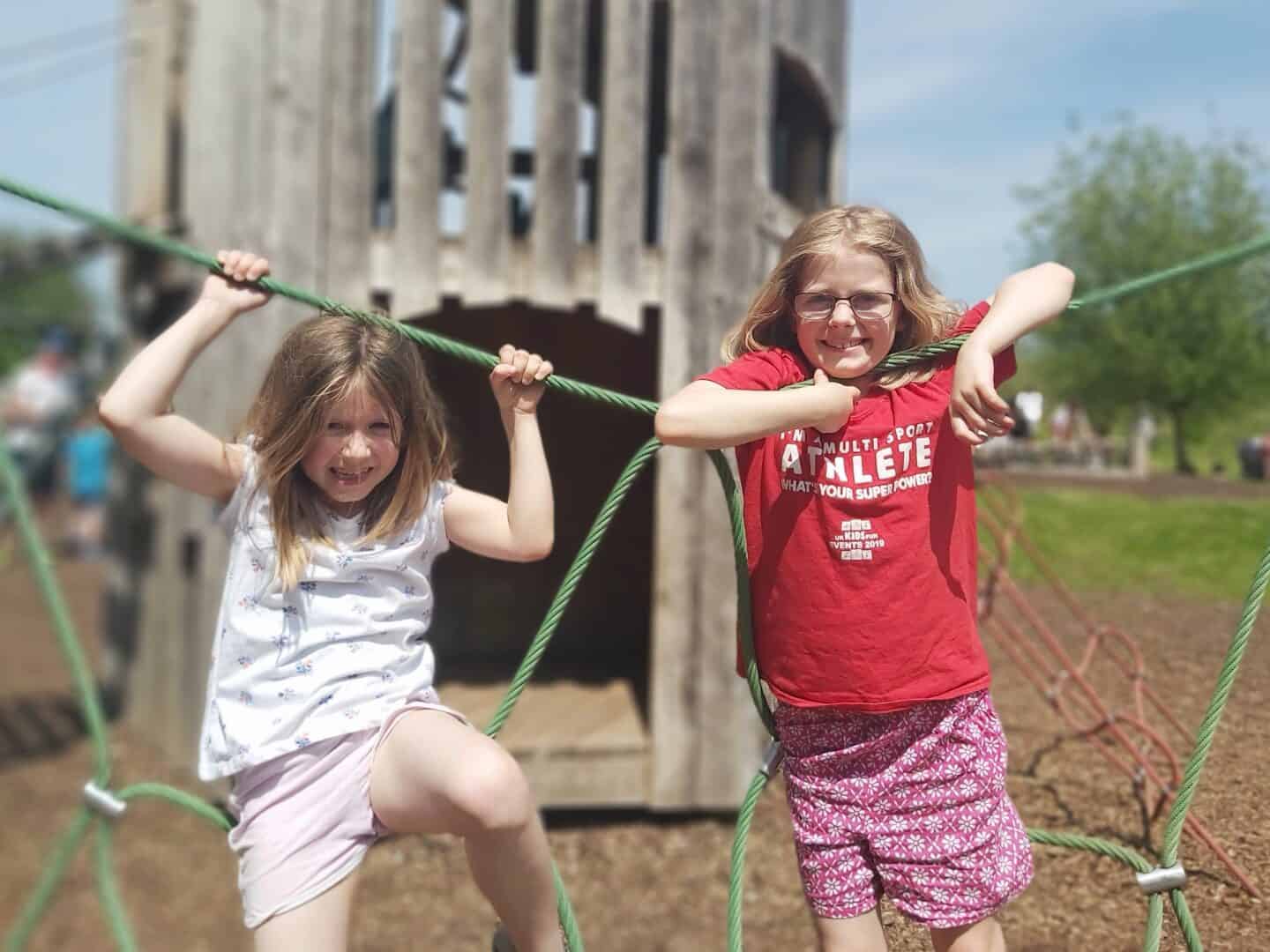 Two girls climbing a web rope at WWT Slimbridge playground