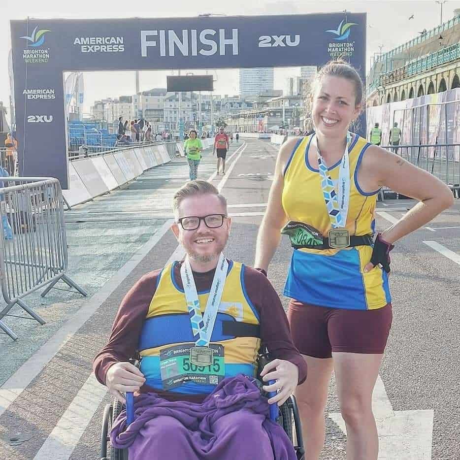 Male wheelchair athlete and female runner at the Brighton Marathon Finish Line