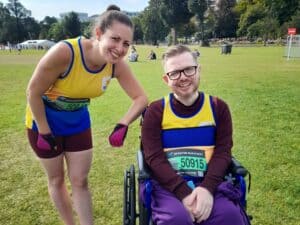 Male wheelchair athlete and female runner at Brighton Marathon start at Preston Park