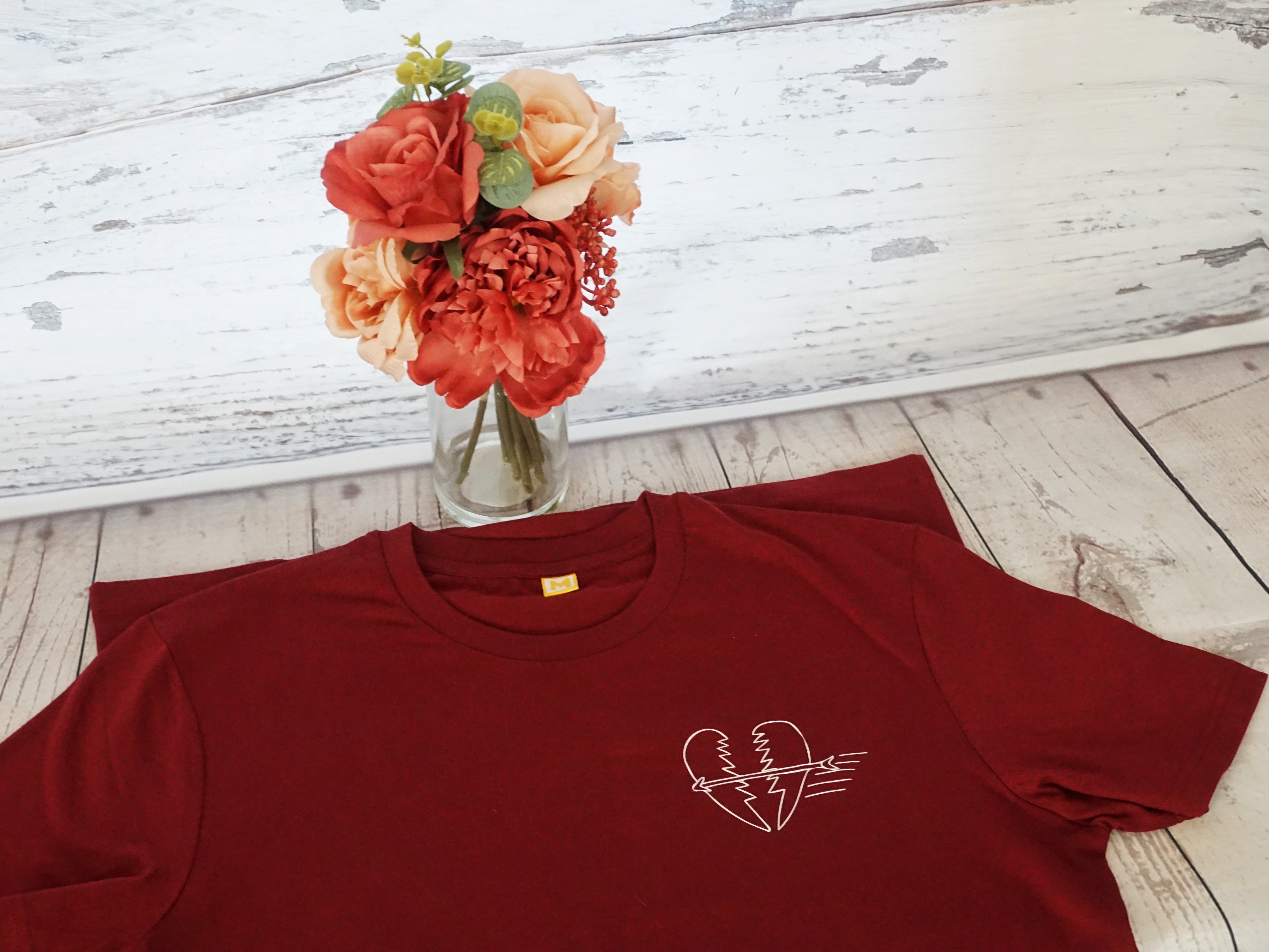 Th3rd Level T-shirt presented against a wooden background with red and peach flowers in a vase behind. Th3rd Level clothing items make great Ethical Mother's Day Gifts due to the companies ethical credentials.  