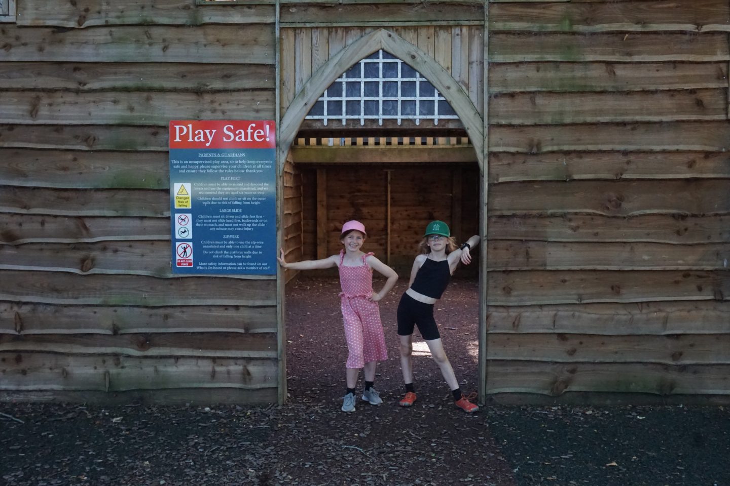 Two girls standing in the doorway into the play castle at the adventure playground