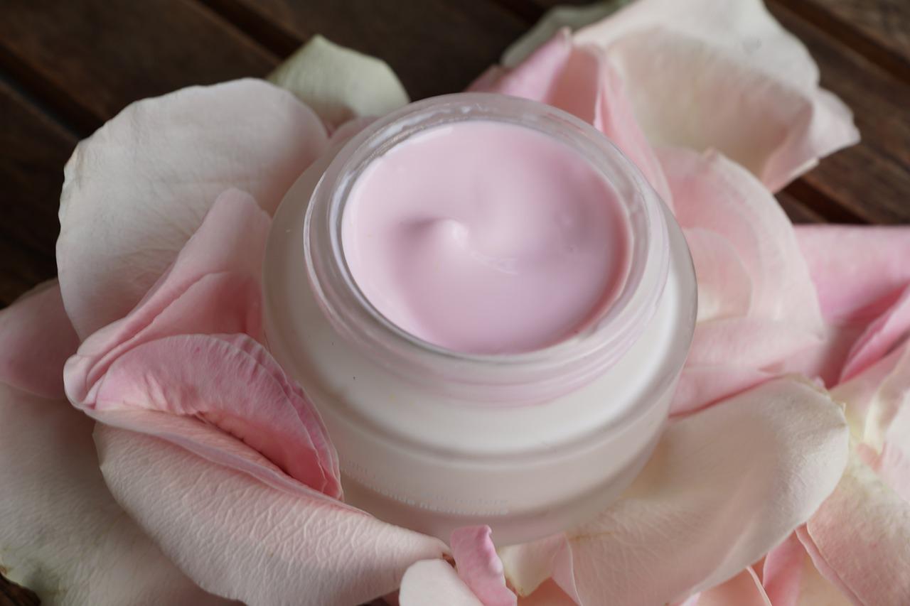 skincare cream in a pot displayed on pink and white rose petals