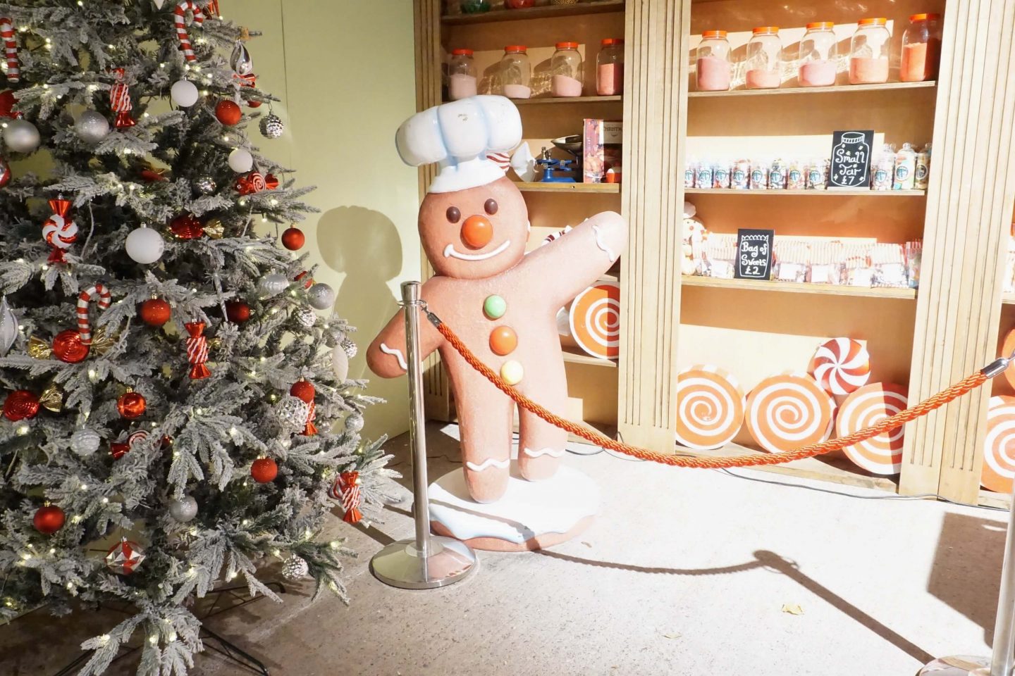 Giant gingerbread man beside sweets for sale in the cookie decorating area of Santa Experience at Winter Glow