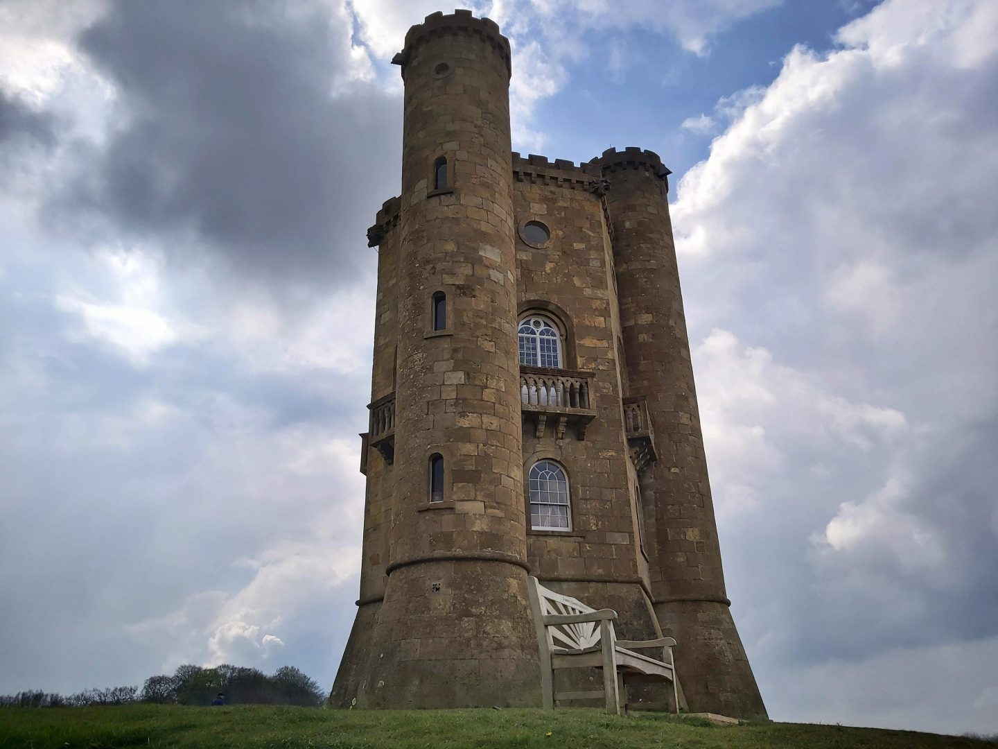 Broadway Tower in Worcestershire photographed from below with a cloudy sky and a small area of blue sky immediately above the tower