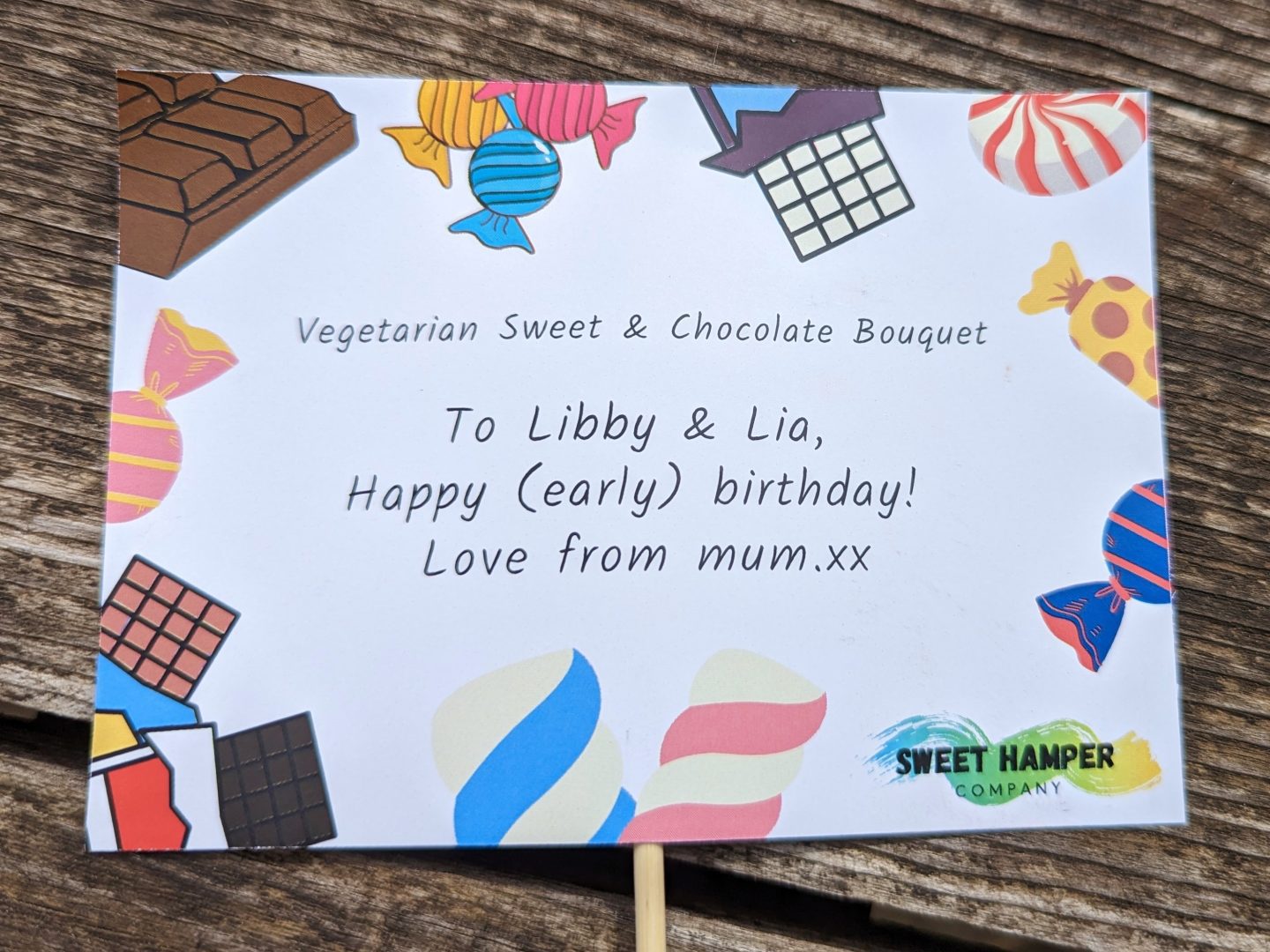 gift card from the Sweet Bouquet Emporium with the words Happy Early Birthday Libby and Lia love from mum.xx and decorated around the outside of the card with sweets