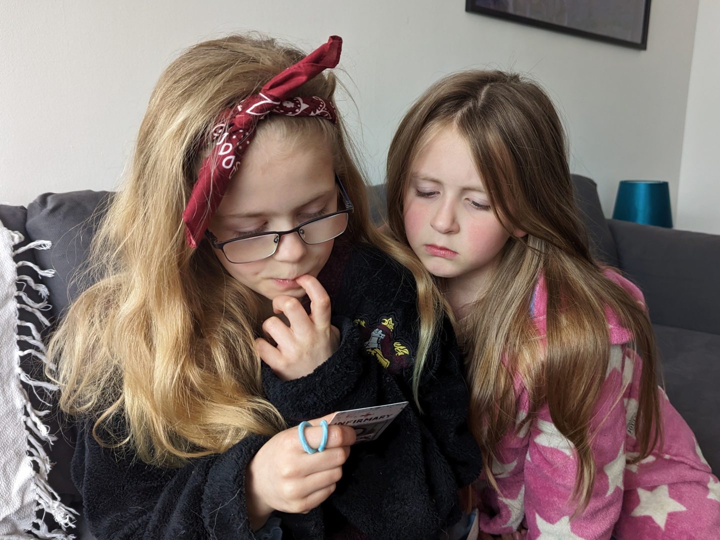 Libby and Lia looking puzzled trying to work out the answer to a question to get their phones back