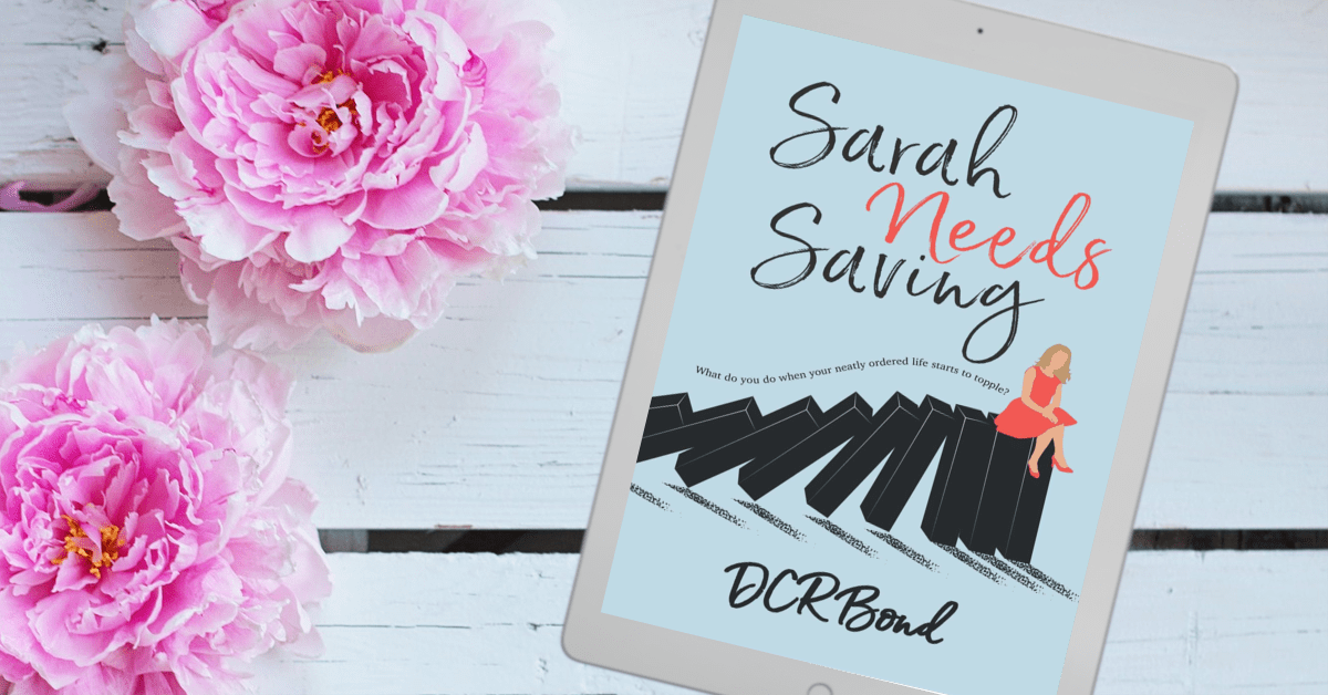 Sarah Needs Saving book by DCR Bond displayed on a white wooden surface beside two large pink flowers