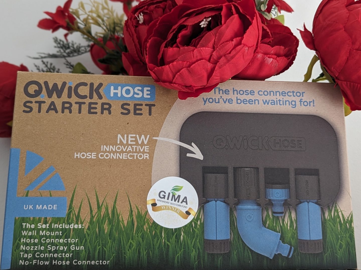 Quick Hose Starter Set in box displayed with red flowers behind