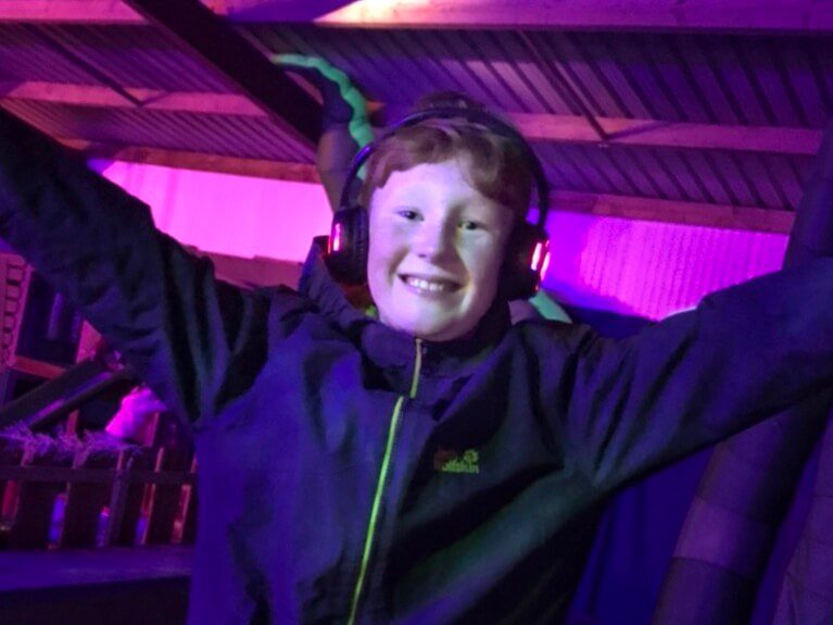 Boy dancing in silent disco at Cotswold Farm Park Enchanted Light Trail