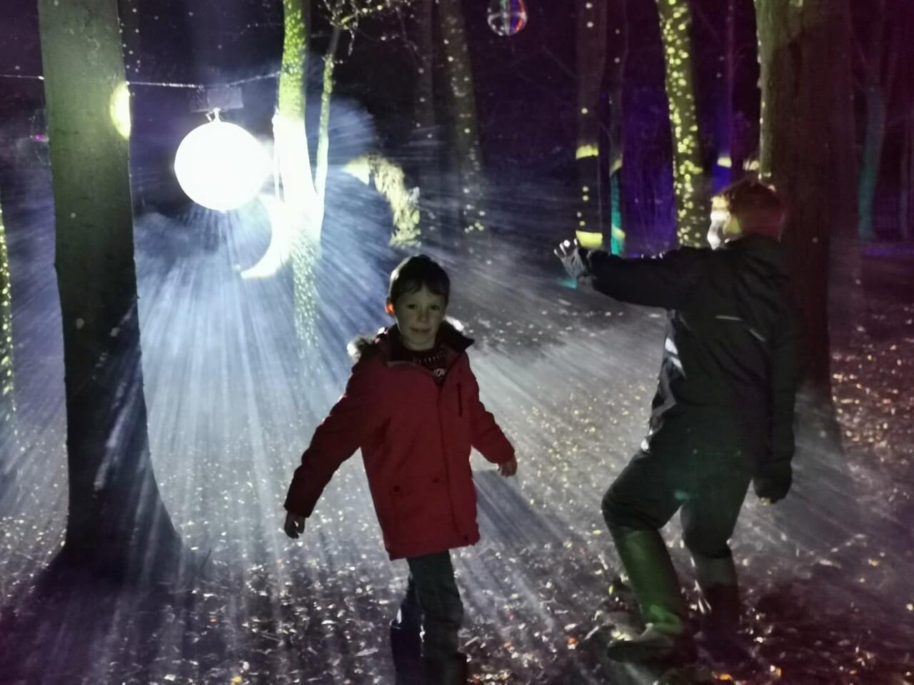 Boys dancing to live music at the Cotswold Farm Park Enchanted Light Trail
