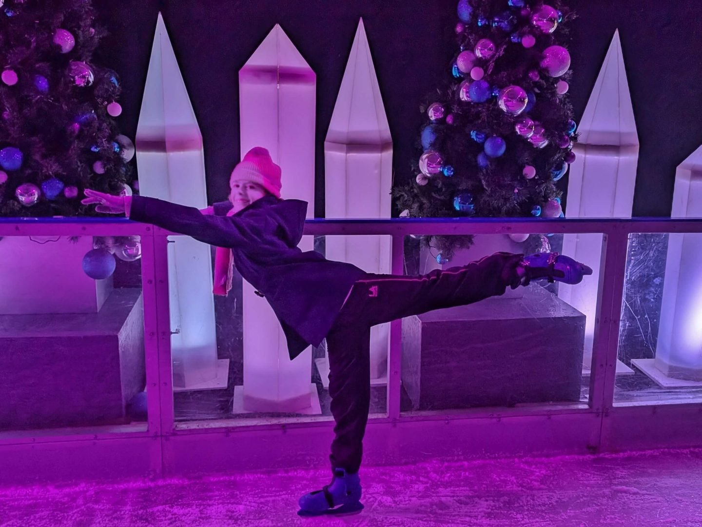 Girl posing in ballet position on Winter Glow ice rink