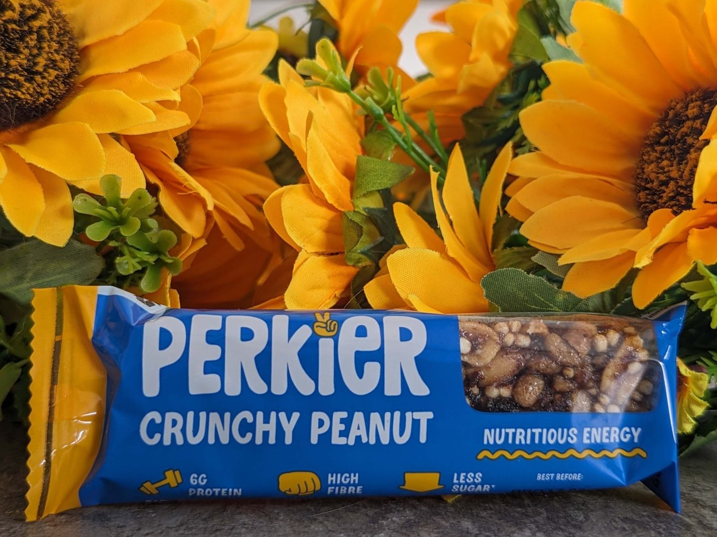Perkier crunchy peanut bar displayed against a bunch of sunflowers.