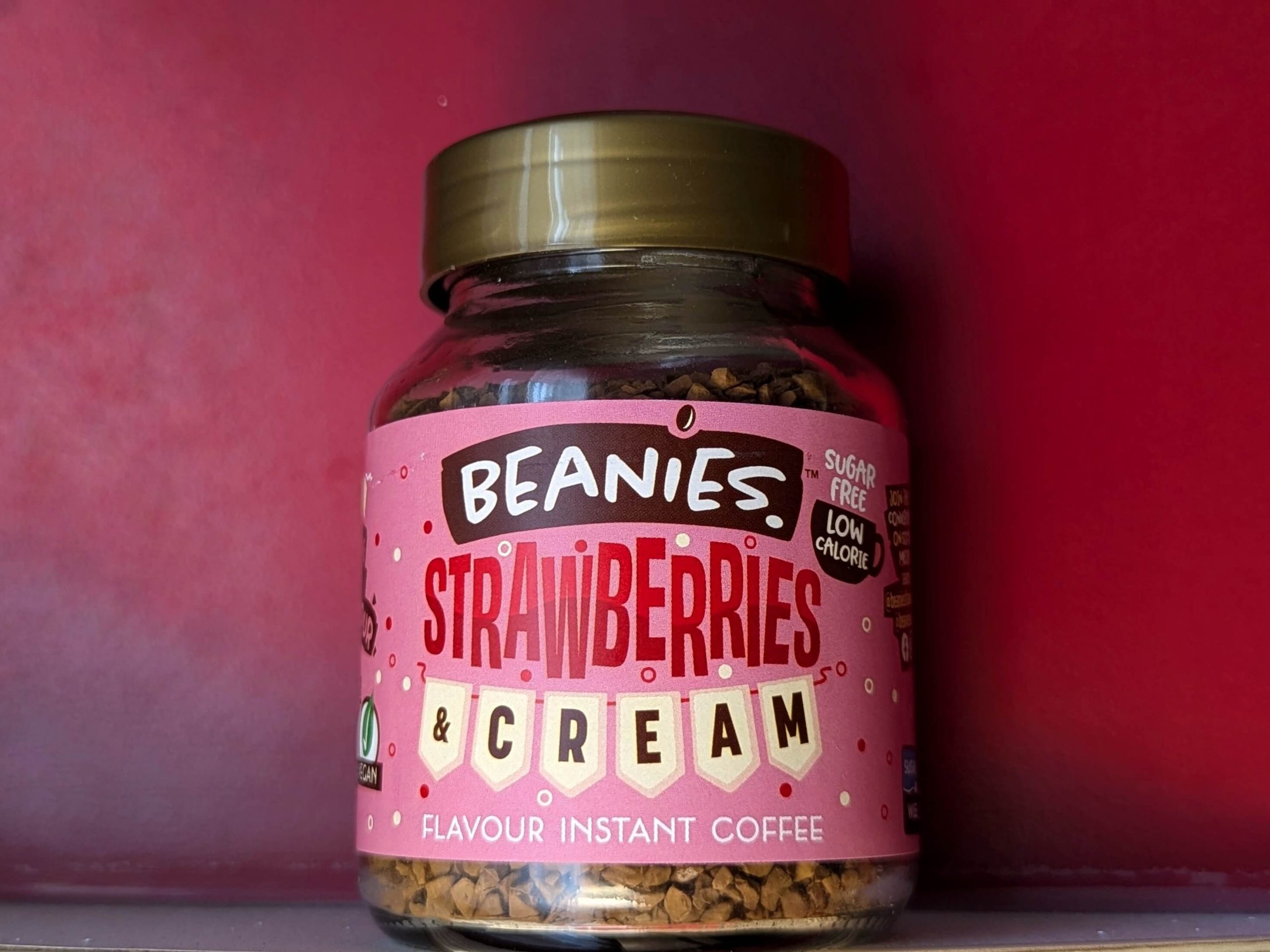 pot of Beanies Strawberries & Cream Instant Coffee against a red background