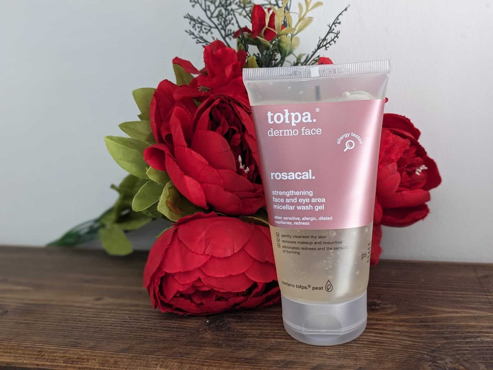 Tolpa Dermo Face Wash Gel for teens and tweens displayed against red Christmas flowers on a dark wood shelf