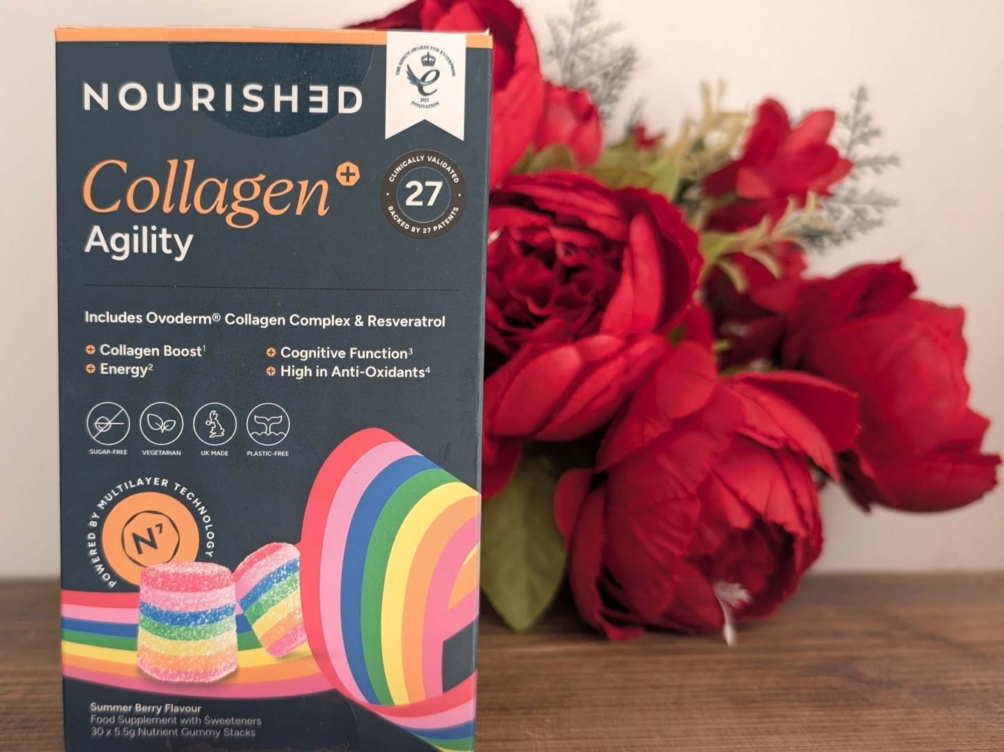 Nourished gummy vitamins displayed in front of red Christmas flowers