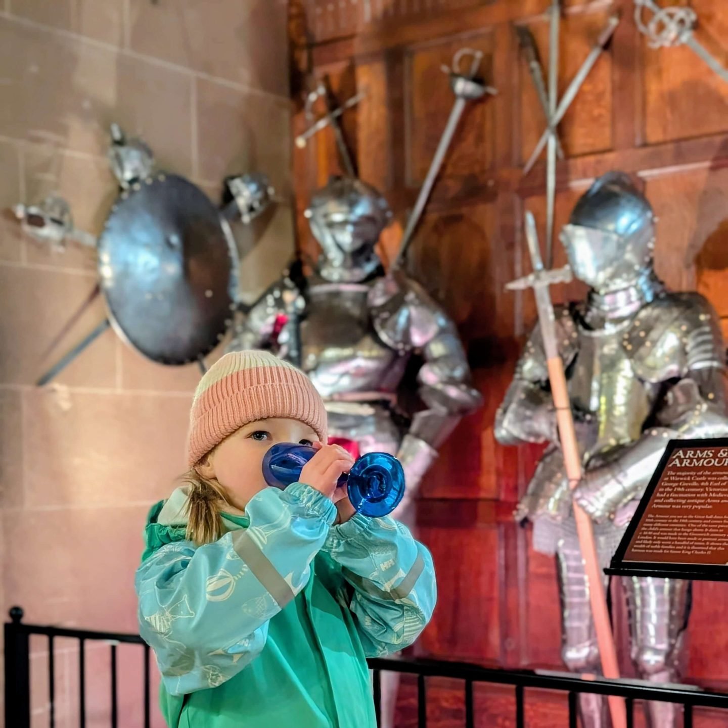 Little girl enjoying a drink by the Knights at Warwick Castle