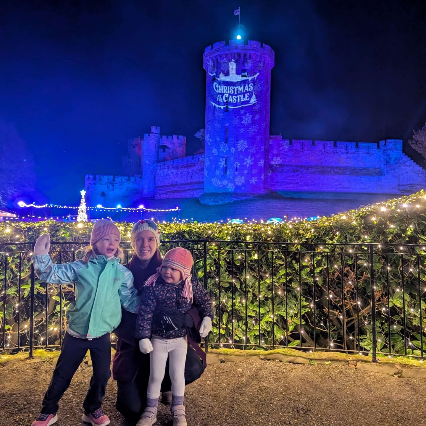 Two girls stood outside at Warwick Castle which is lit up for Christmas at the Castle