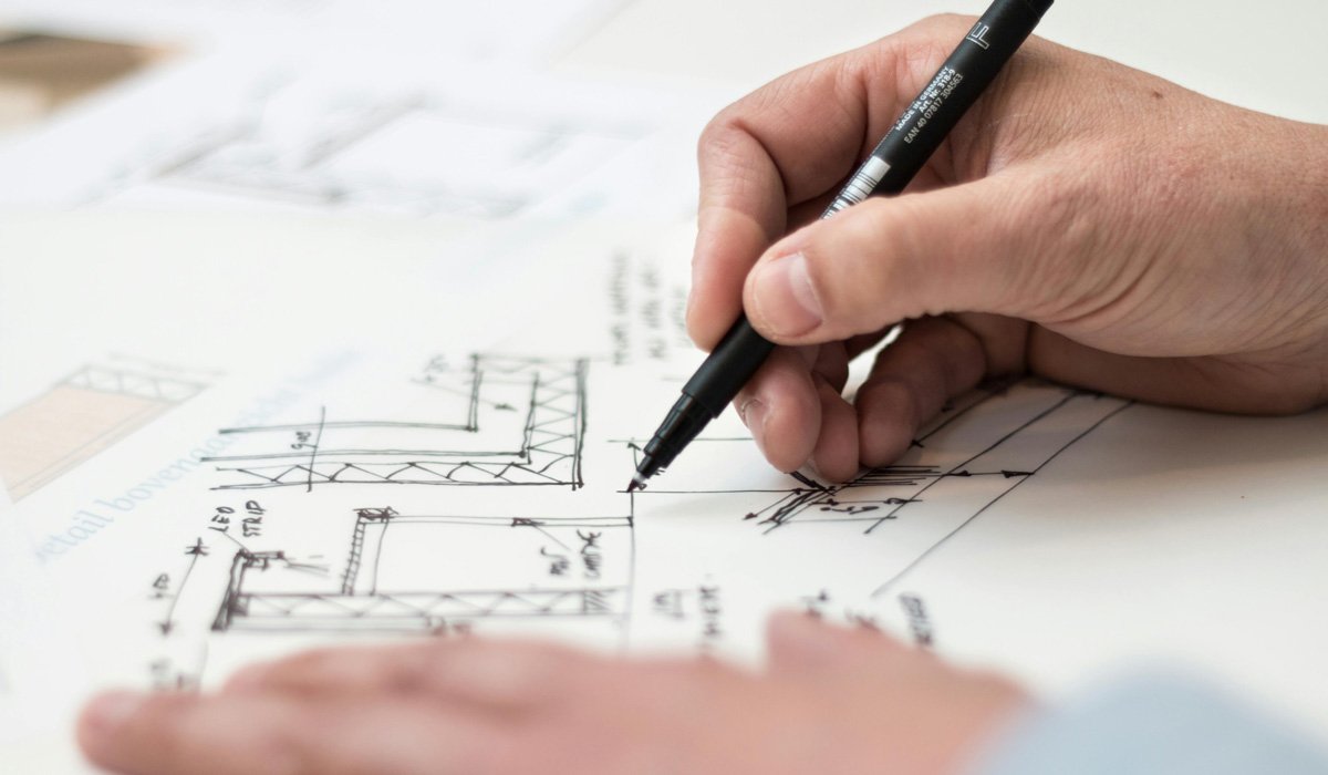 Architect sketching building plans on a blueprint