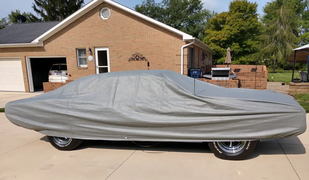 Classic car covered with a grey car cover