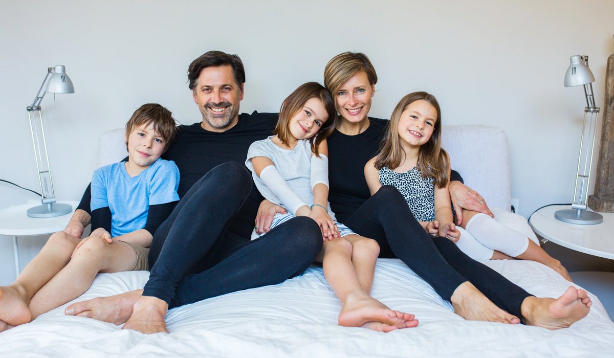 Happy family sitting together on bed