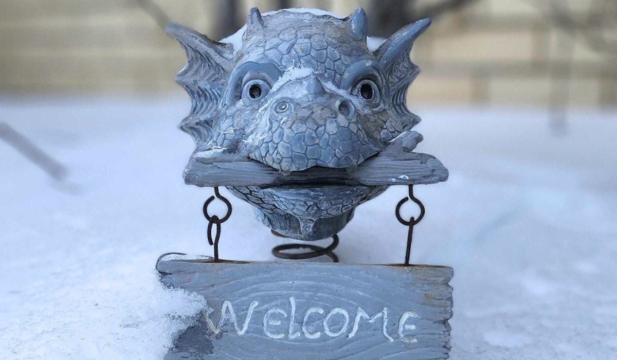 Dragon welcome sign garden statue in snow