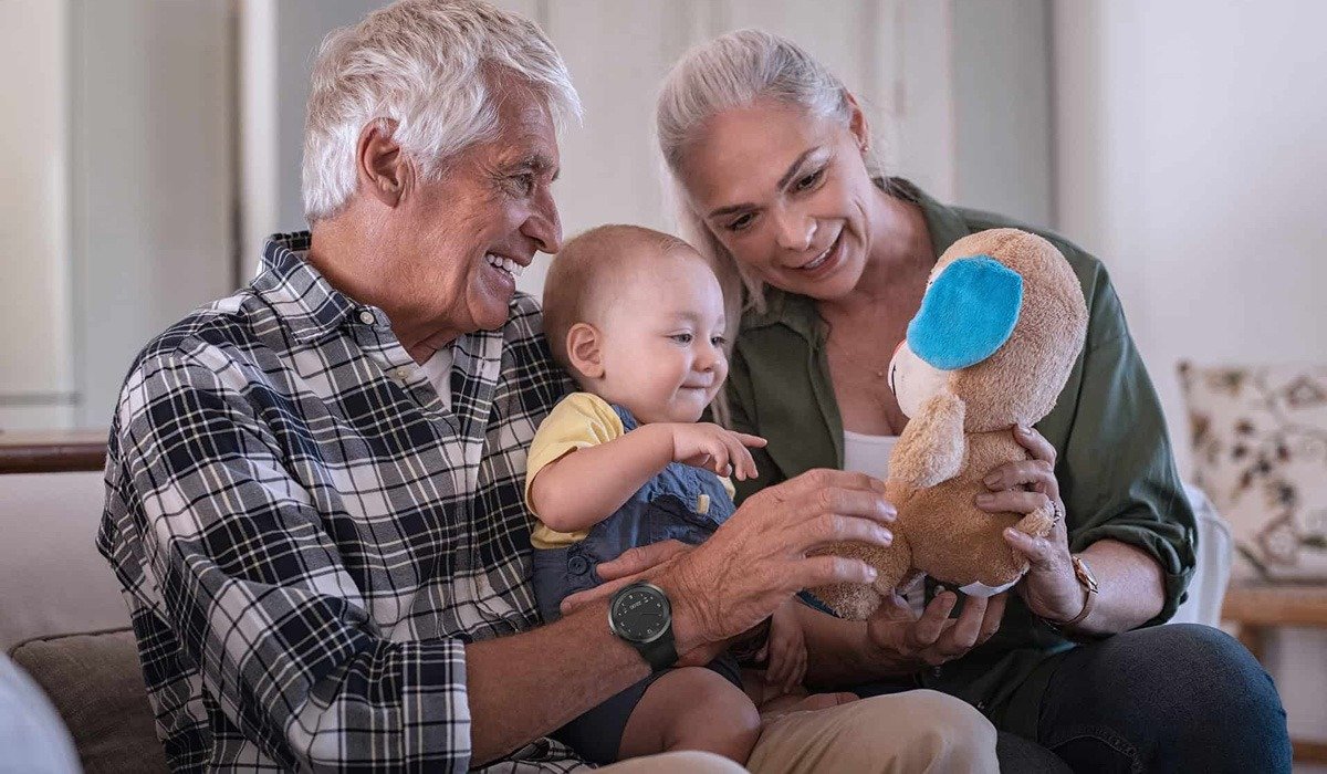 Grandparents playing with a baby and a stuffed toy