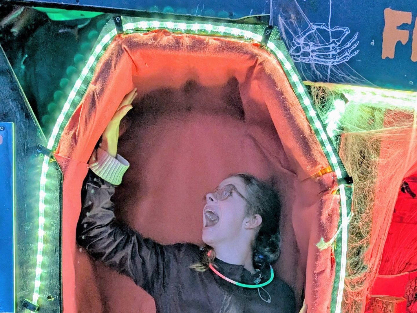 Teenager standing in a coffin at Ralph Court Gardens Halloween evening event